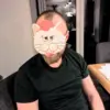 Ein Kundenbild Mann im schwarzen T-Shirt hat eine selbstgebastelte Katzenmaske aus dem Bastelset auf dem Gesicht