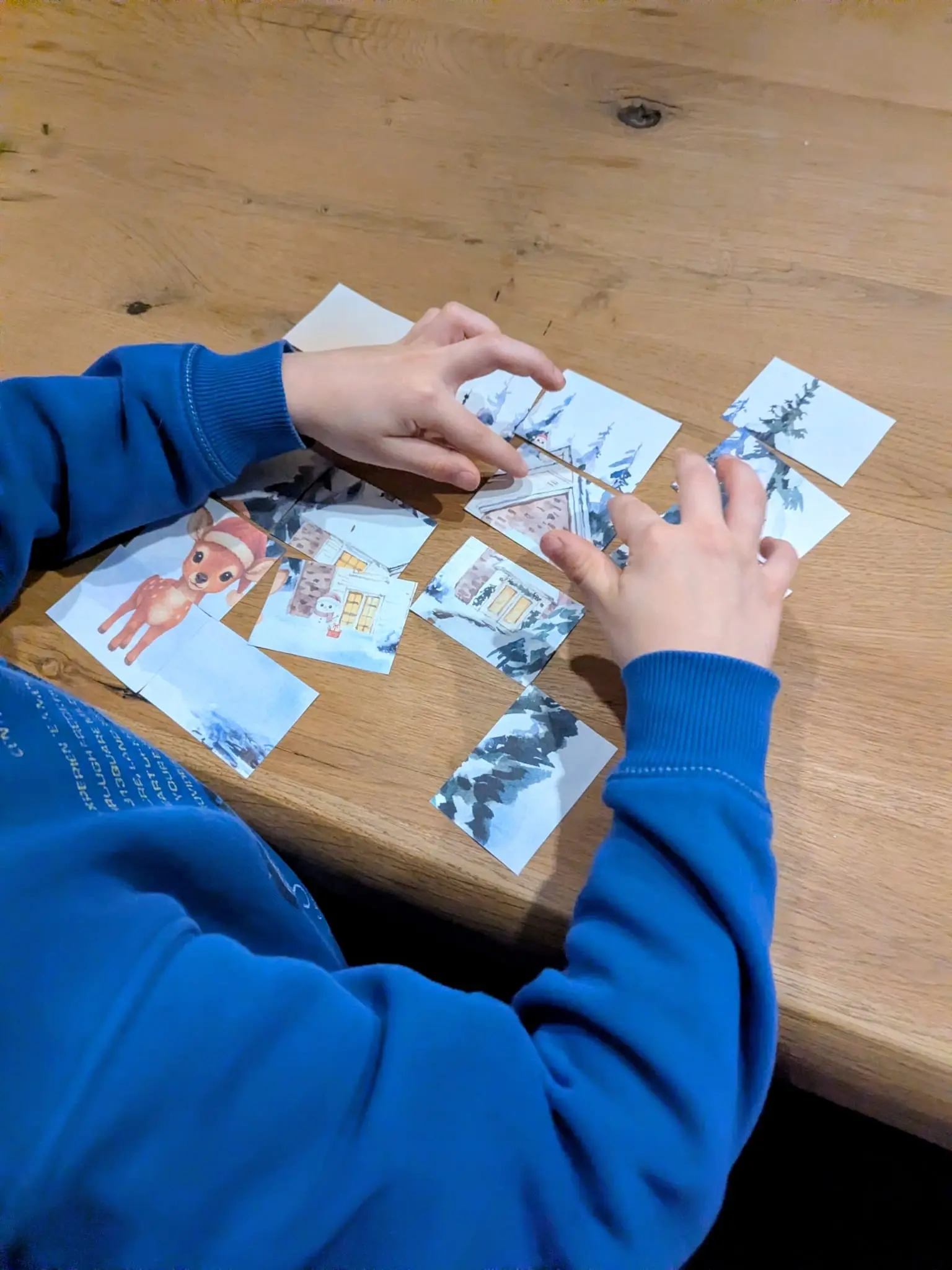 Kinderhände, die ein ausgedrucktes Puzzle-Bild zusammenfügen