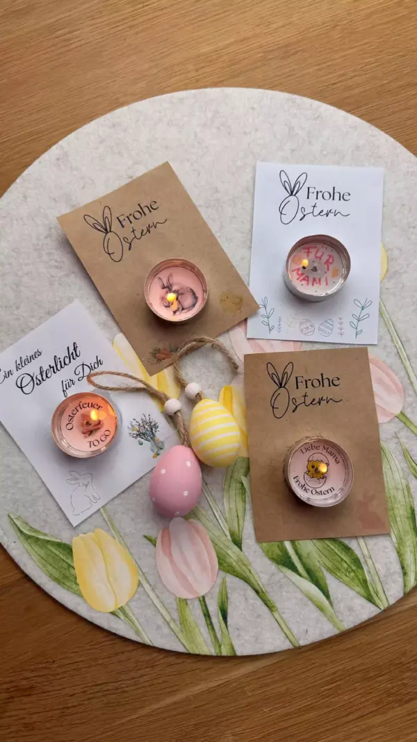 4 Teelichter mit sichtbarer Botschaft im Wachs auf Ostergrusskärtchen. Dekoriert auf einer Frühlingsunterlage mit Tulpen
